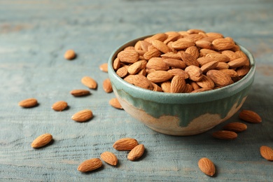 Tasty organic almond nuts in bowl on table