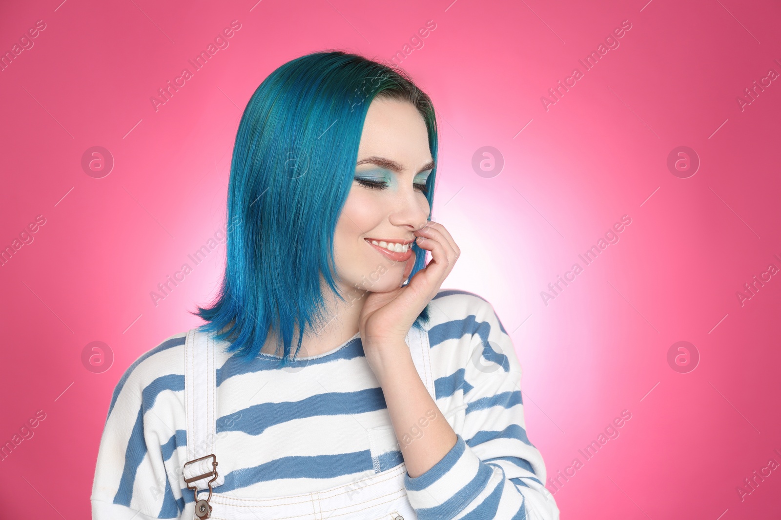 Photo of Young woman with bright dyed hair on pink background