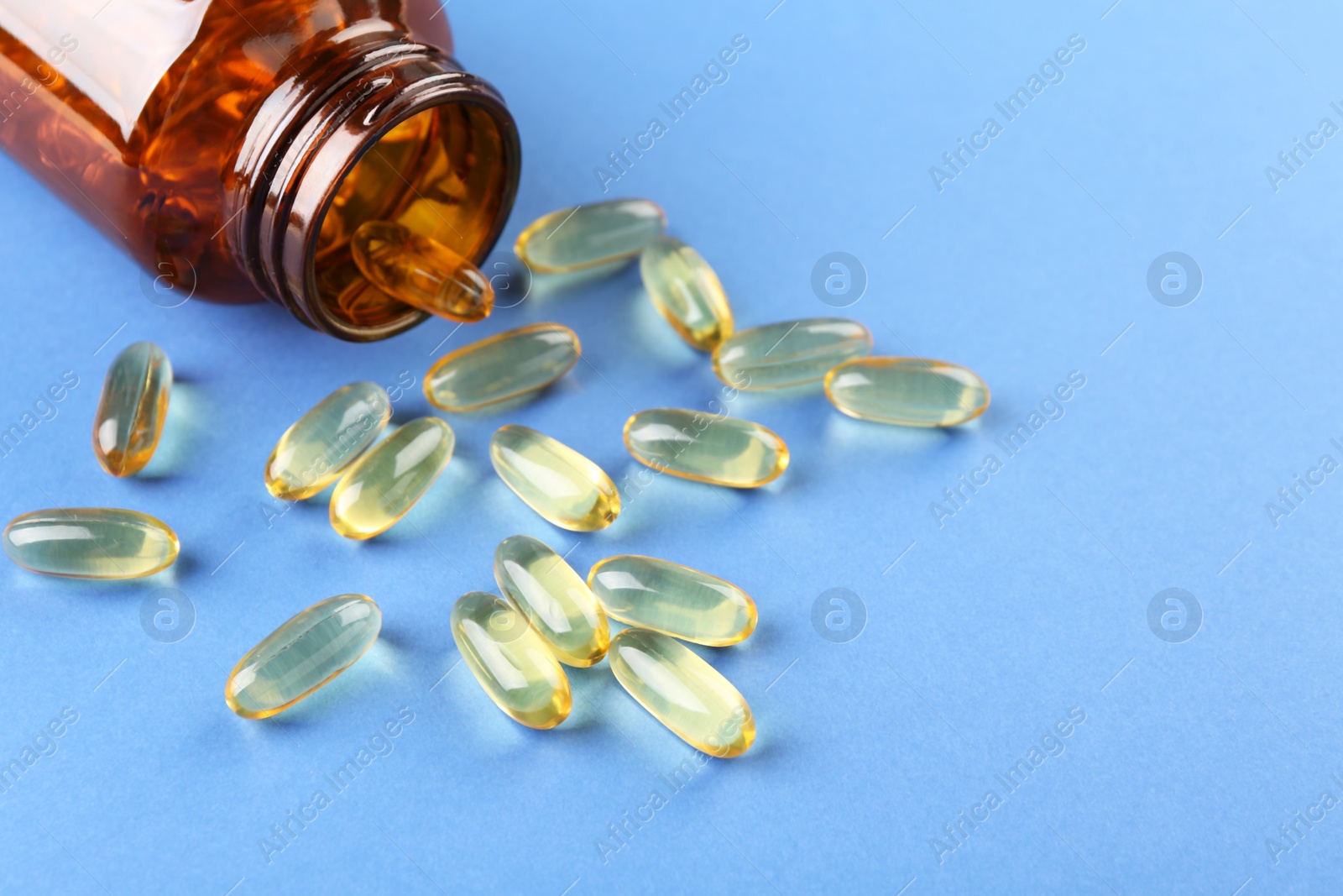 Photo of Jar with vitamin capsules on blue background, closeup. Space for text