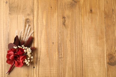 Photo of Beautiful boutonniere on wooden background, top view. Space for text