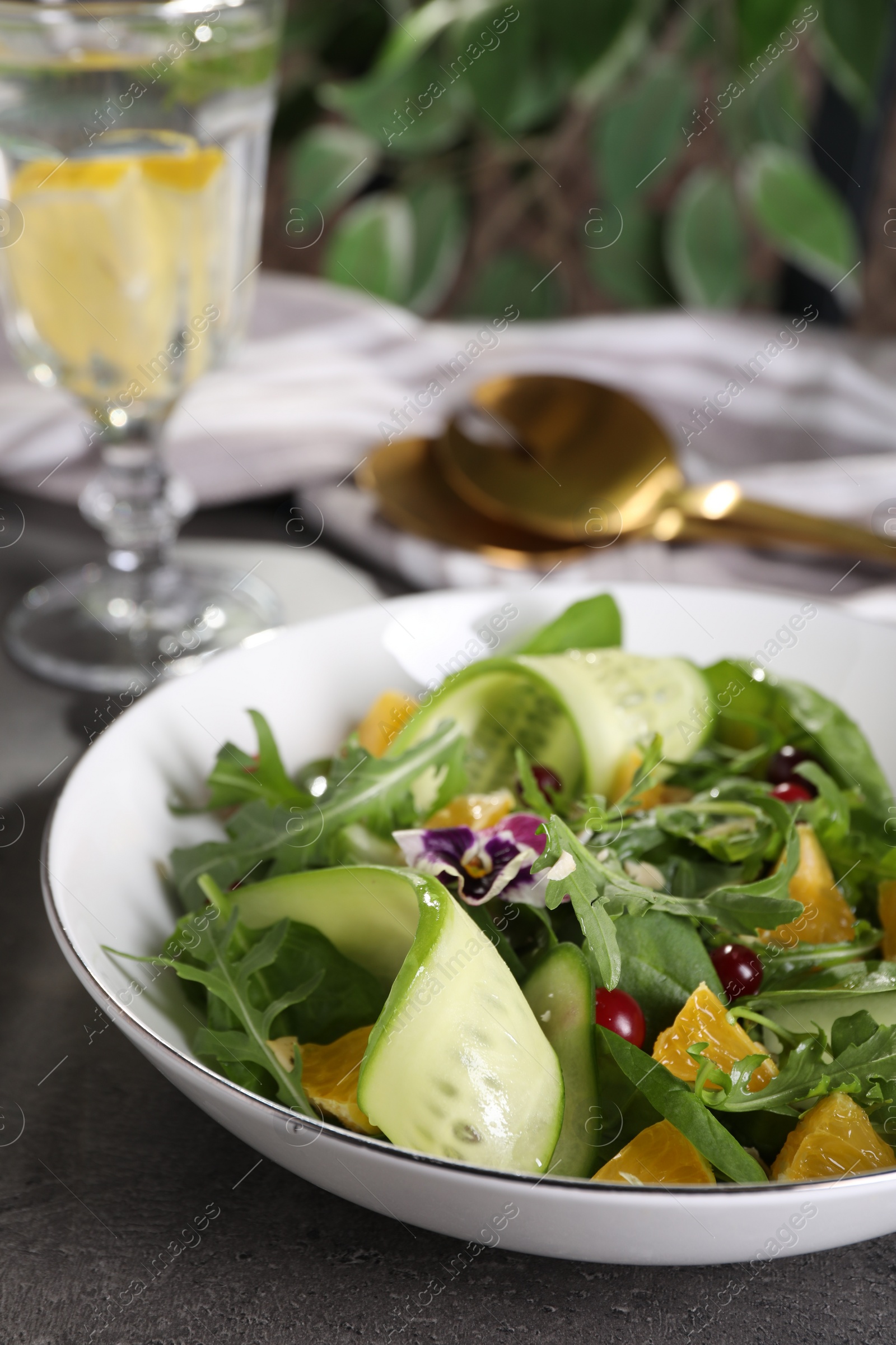 Photo of Delicious salad with cucumber and orange slices on table