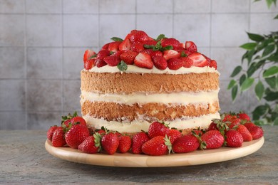 Tasty cake with fresh strawberries and mint on gray table