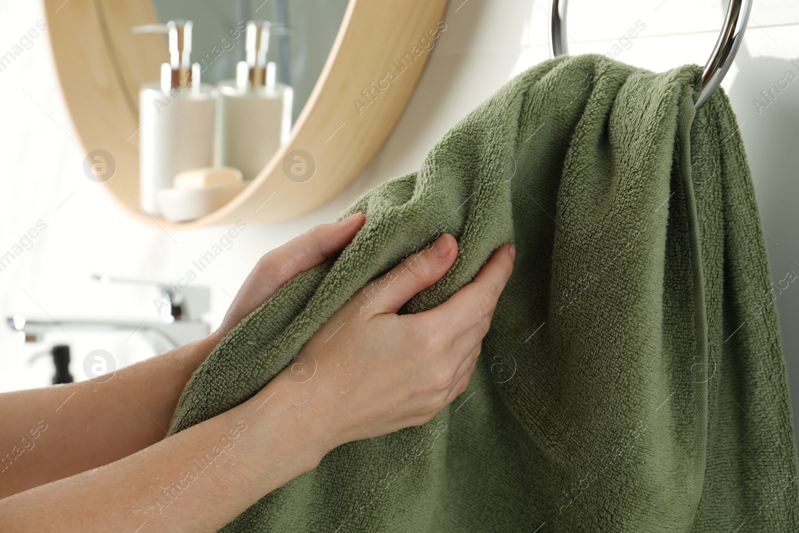 Photo of Woman wiping hands with towel in bathroom, closeup