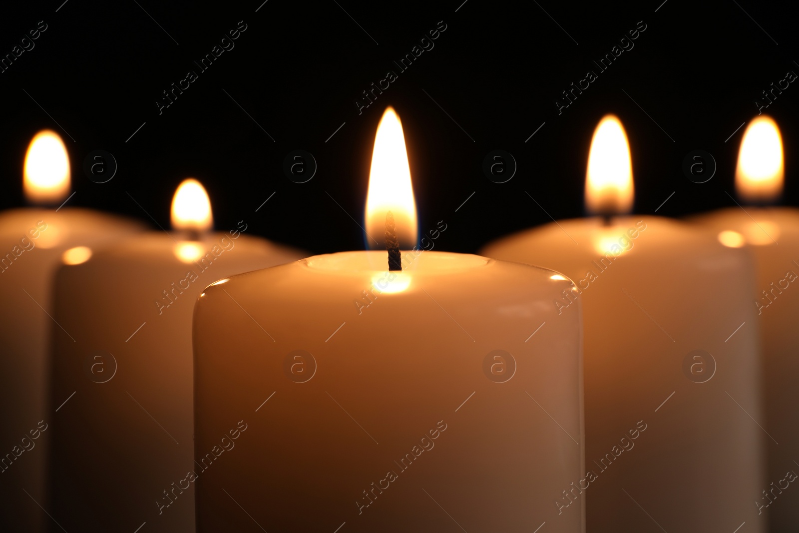 Photo of Burning candles on dark background, closeup. Memory day