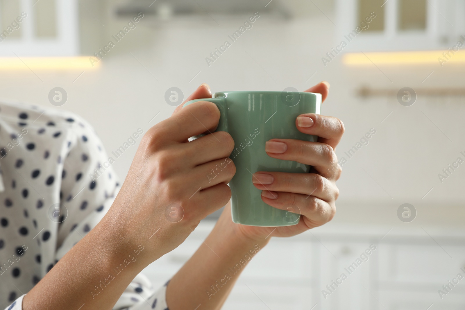 Photo of Woman with green cup at home, closeup