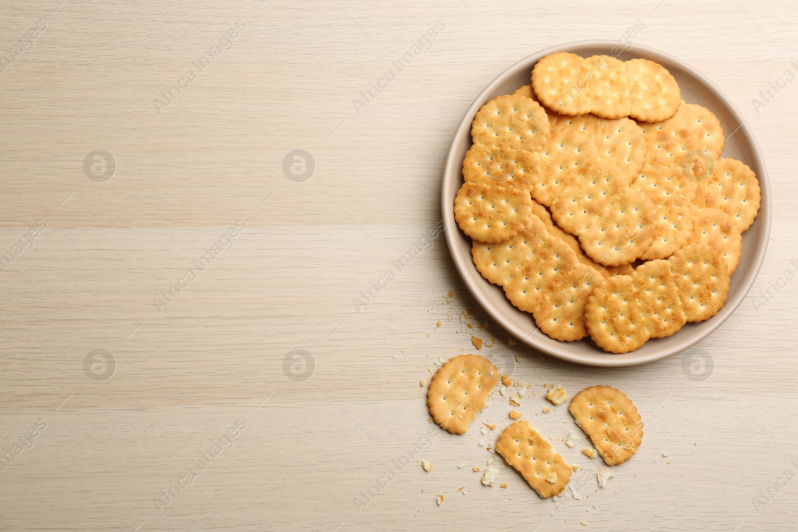 Photo of Delicious crispy crackers on wooden table, flat lay. Space for text