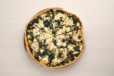 Photo of Delicious homemade spinach quiche on white wooden table, top view