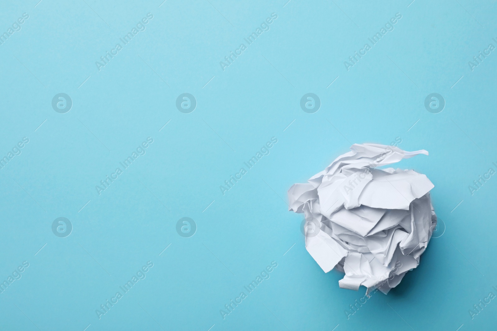 Photo of Crumpled sheet of paper on color background, top view. Space for text
