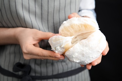 Photo of Woman with tasty fresh pomelo on black background, closeup