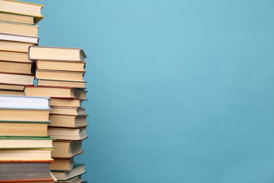 Photo of Many hardcover books on turquoise background, space for text. Library material