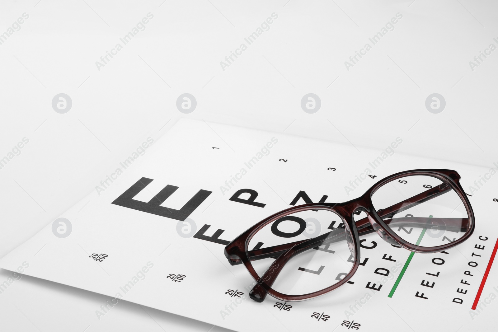 Photo of Glasses and vision test chart isolated on white