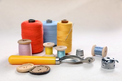 Photo of Color threads, tracing wheel and other sewing accessories on white table