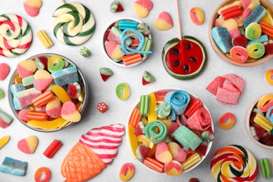 Many tasty colorful jelly candies on white table, flat lay