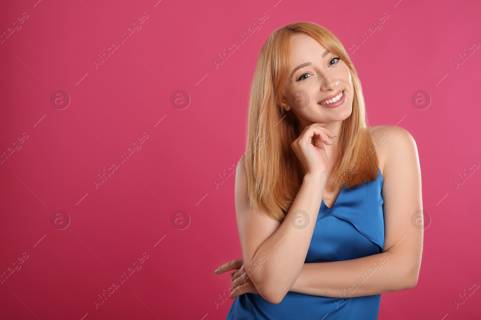 Photo of Beautiful young woman with blonde hair on pink background. Space for text