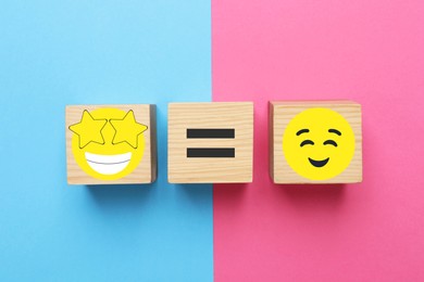 Image of Wooden cubes with equal, star-struck and smiling face emoticons on color background, flat lay