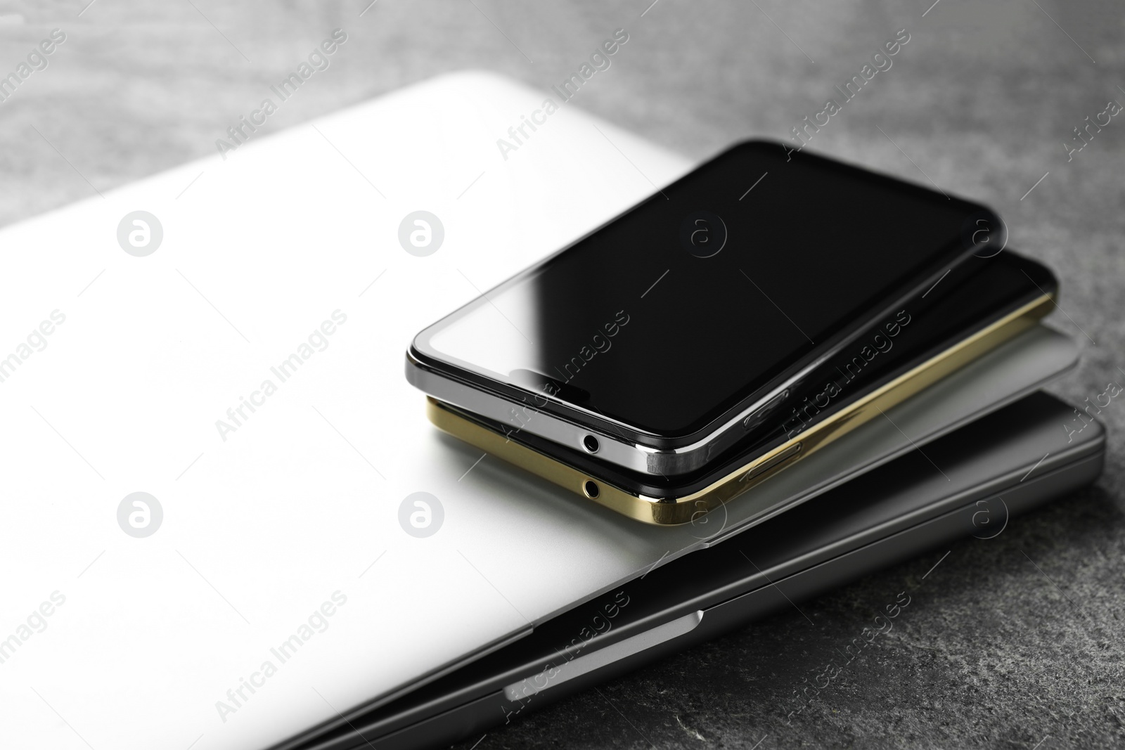 Photo of Stack of electronic devices on grey table, closeup