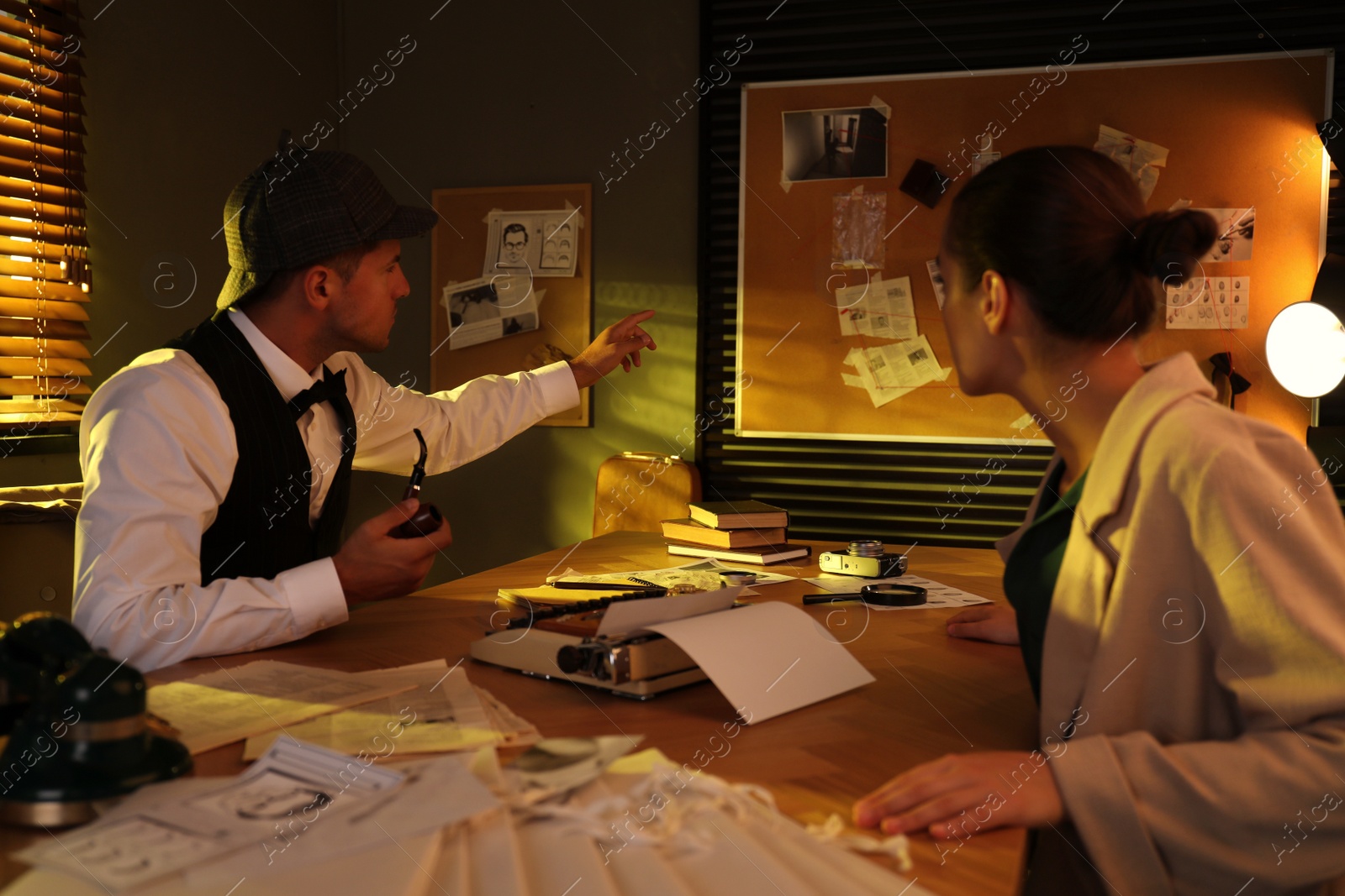 Photo of Old fashioned detective working with client in office