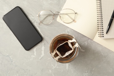 Photo of Flat lay composition with drip coffee in cup on light grey marble table