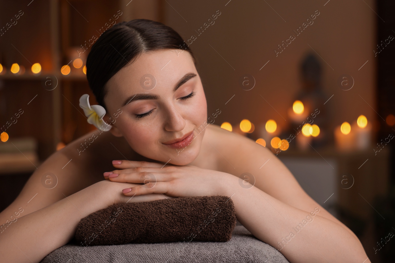 Photo of Spa therapy. Beautiful young woman lying on massage table in salon