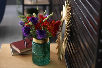 Glass vase with fresh flowers on wooden table