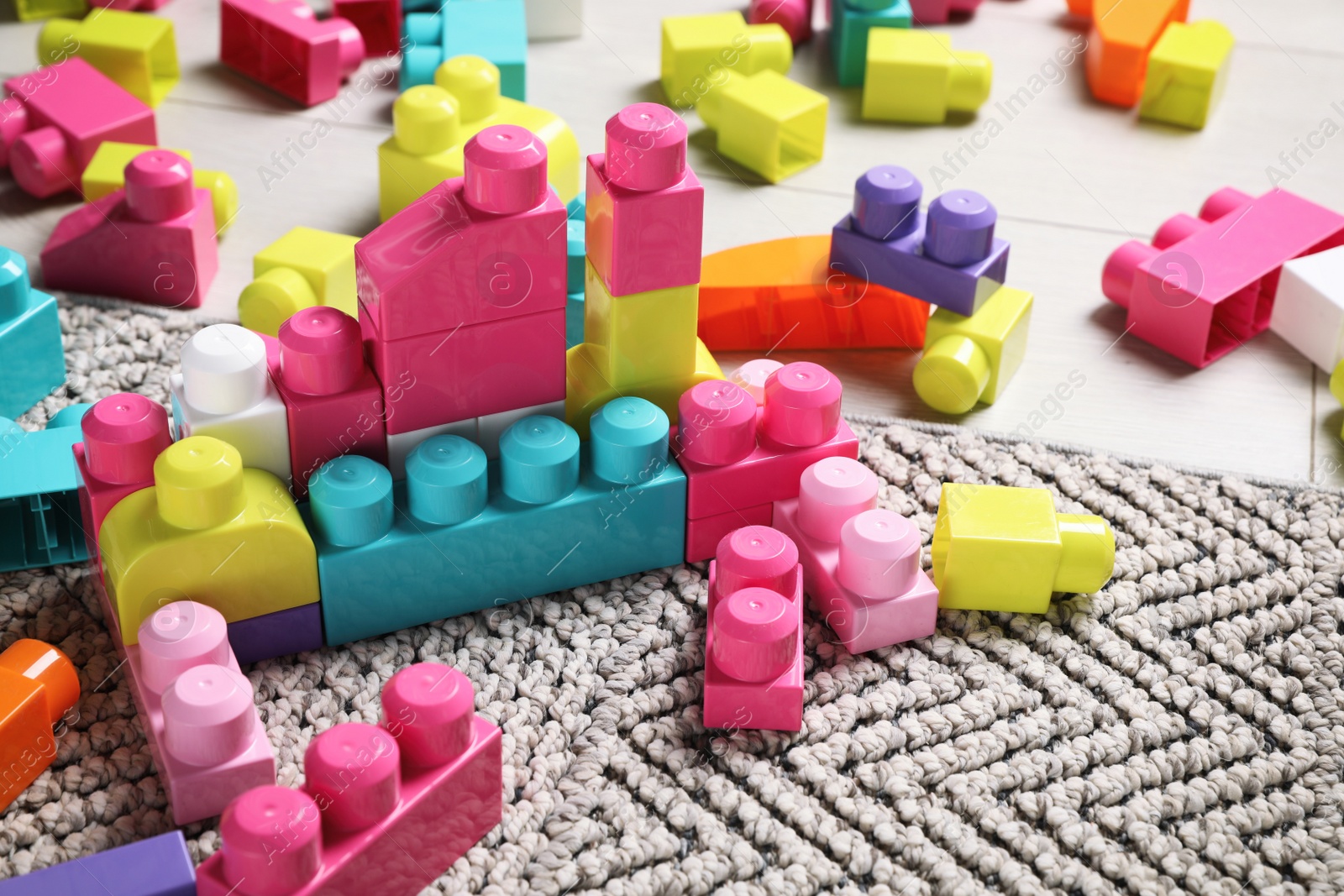 Photo of Colorful plastic building blocks on grey carpet