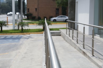 Concrete ramp with metal handrail near building outdoors, closeup
