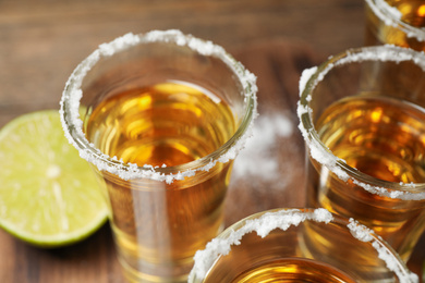 Photo of Mexican Tequila shots with salt on table, closeup