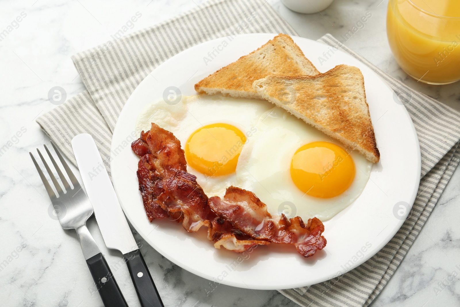 Photo of Delicious breakfast with sunny side up eggs served on white marble table, closeup