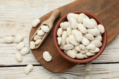 Photo of Uncooked white beans on wooden table, flat lay