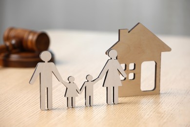 Photo of Family law. Figure of parents with children, house model and gavel on wooden table