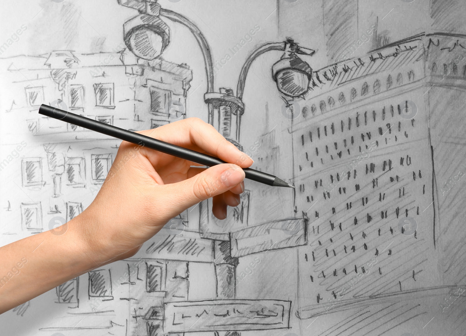 Image of Woman drawing sketch of city street with graphite pencil on white paper, closeup