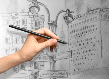 Image of Woman drawing sketch of city street with graphite pencil on white paper, closeup