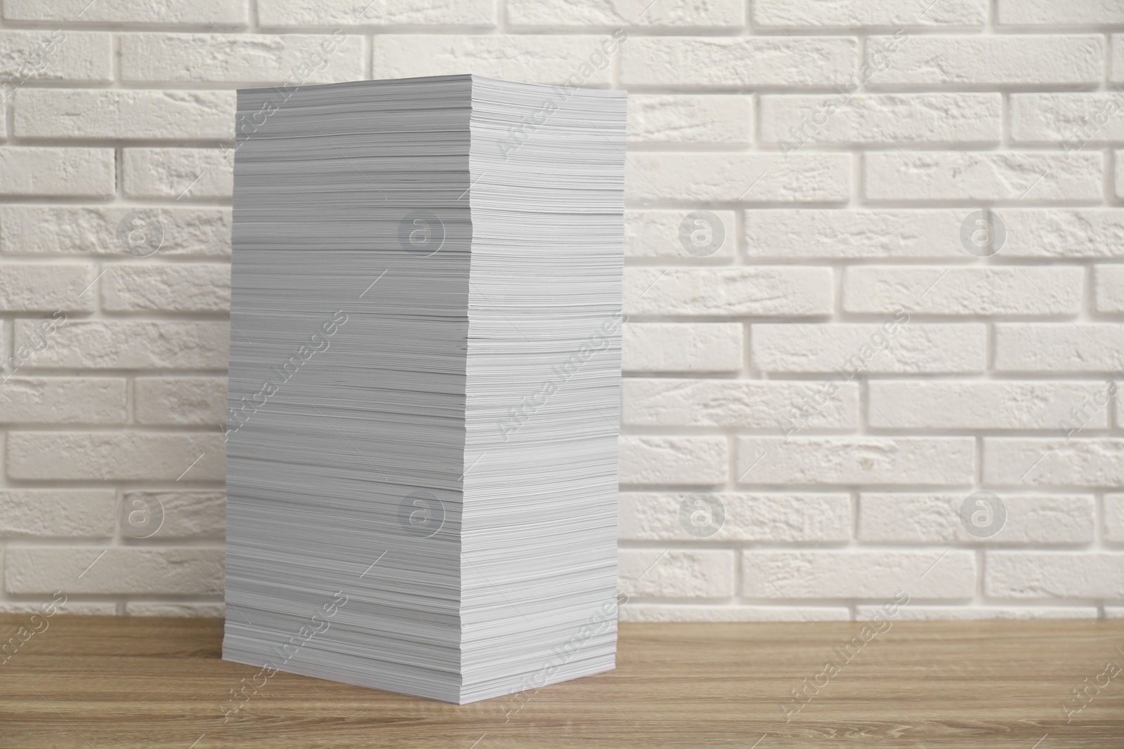 Photo of Stack of paper sheets on wooden table. Space for text