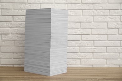 Photo of Stack of paper sheets on wooden table. Space for text