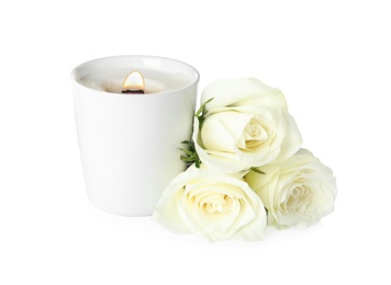 Photo of Aromatic candle with wooden wick and beautiful flowers on white background