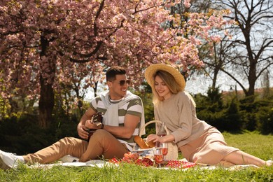 Photo of Happy couple having picnic in park on sunny day