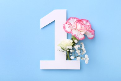 Photo of Paper number 1 and beautiful flowers on light blue background, top view