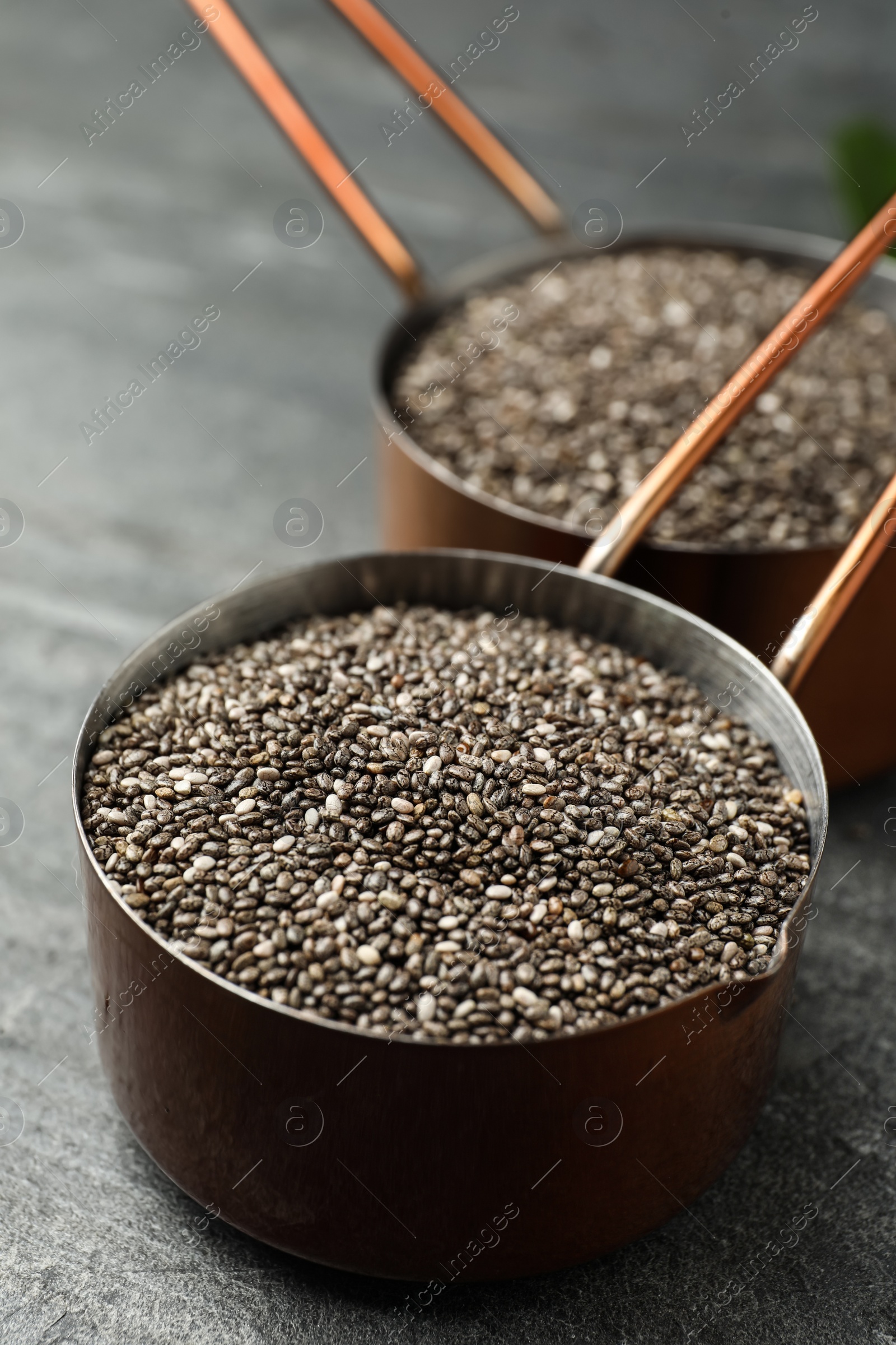 Photo of Saucepan with chia seeds on slate table