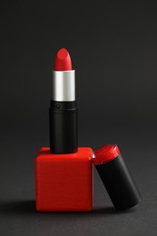 Photo of Beautiful lipstick on black background. Cosmetic product