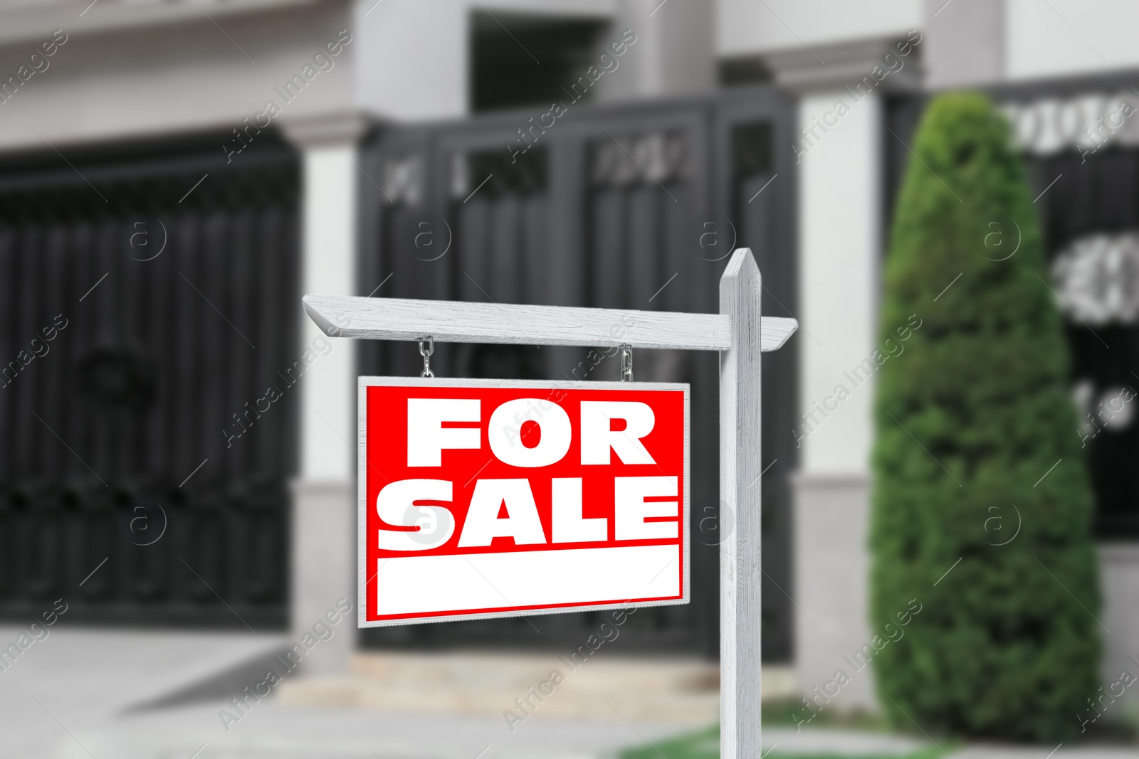 Image of Sale sign near beautiful house outdoors. Red signboard with words