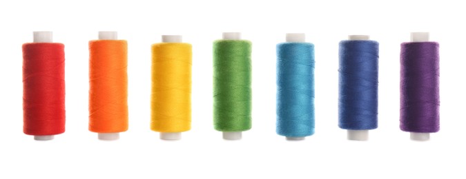 Photo of Set of colorful sewing threads on white background
