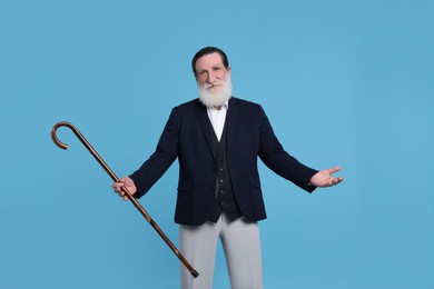 Photo of Senior man with walking cane on light blue background