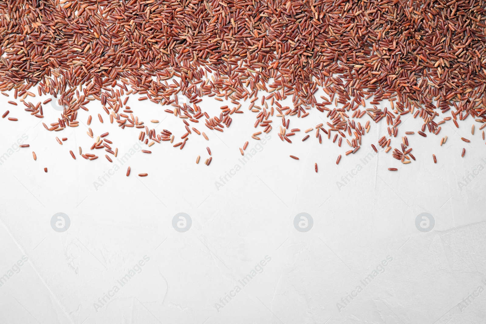 Photo of Brown rice on white background, top view