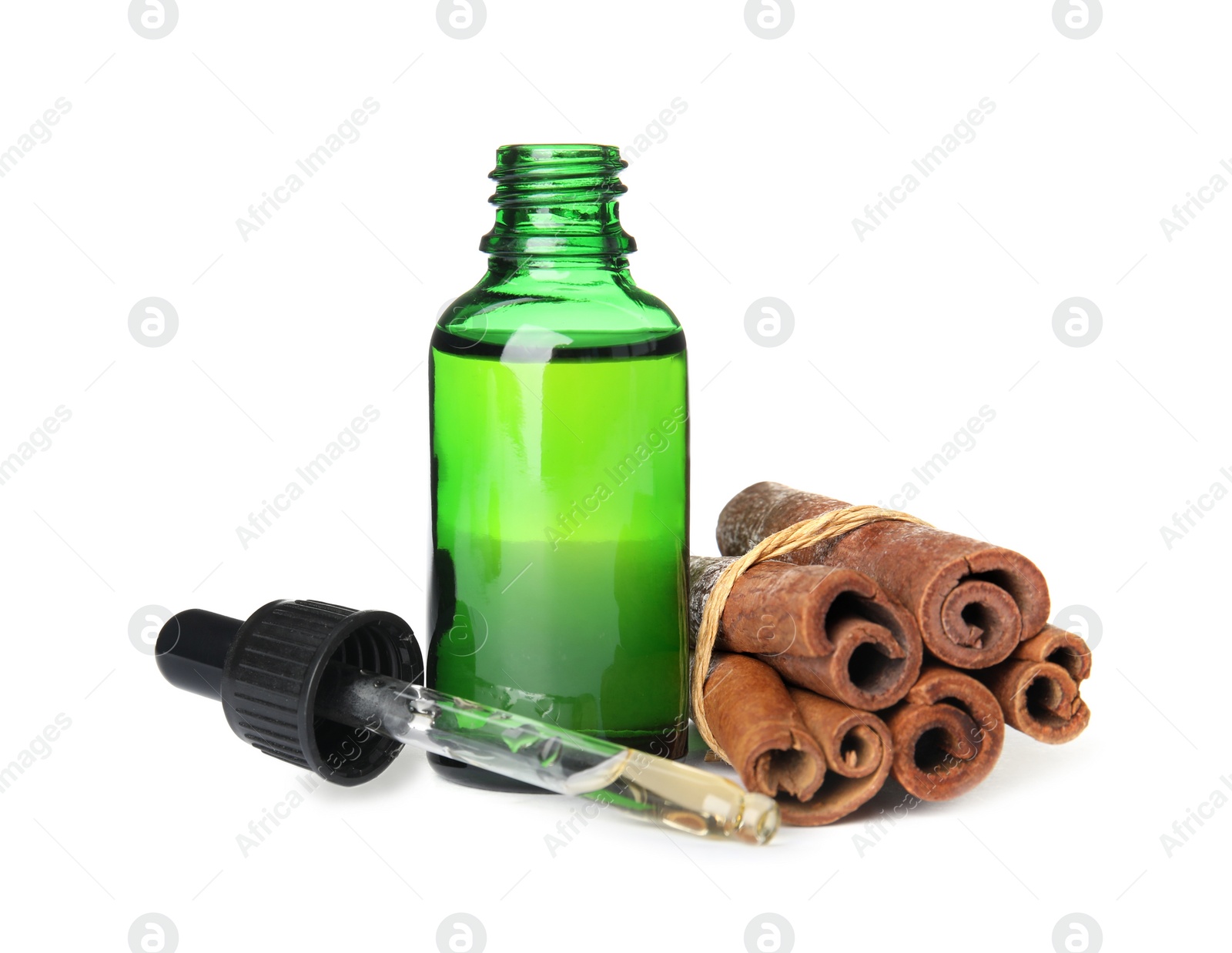 Photo of Bottle of essential oil and cinnamon sticks on white background