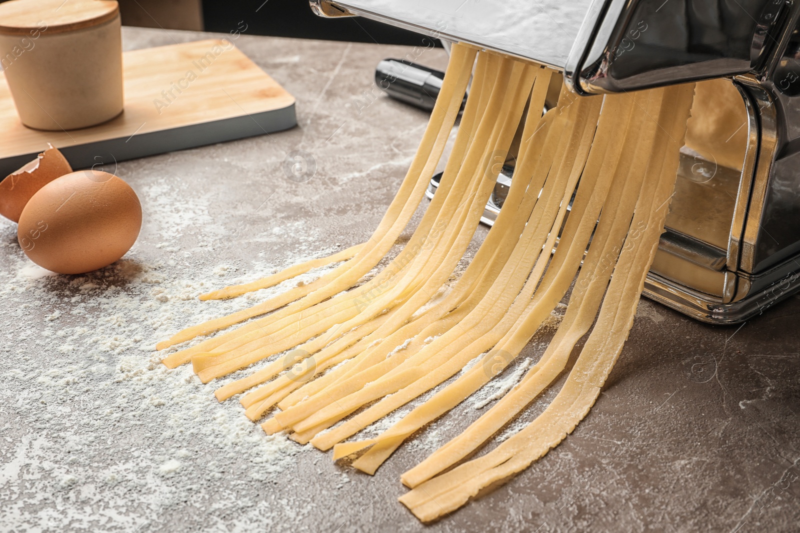 Photo of Pasta maker with dough and eggs on kitchen table