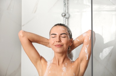 Image of Beautiful young woman washing hair in shower at home