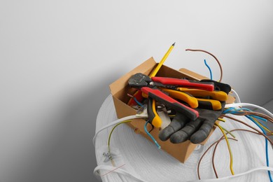 Different tools and cables in paper indoors. Installation of electrical wiring