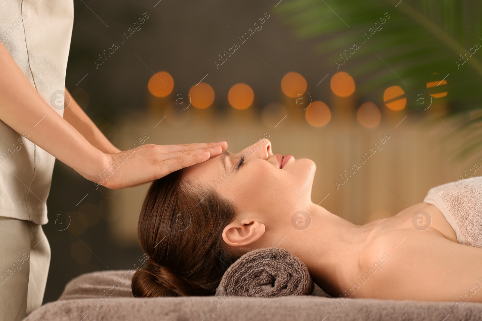 Photo of Beautiful young woman enjoying massage in spa salon