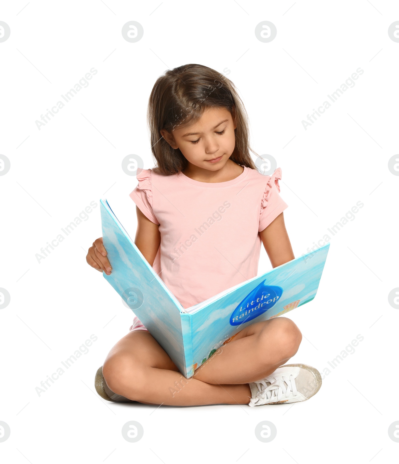 Photo of Cute little girl reading book on white background