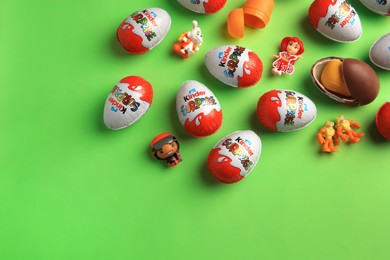 Photo of Sveti Vlas, Bulgaria - June 26, 2023: Kinder Surprise Eggs, plastic containers and toys on light green background, flat lay. Space for text